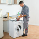 Technician Checking Washing Machine With Digital Multimeter