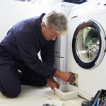 Plumber Fixing Domestic Washing Machine