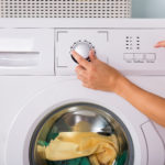 Person Hand Pressing Button Of Washing Machine