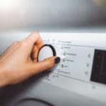 Woman choosing program on washing machine