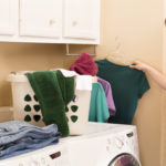 Domestic Life:  Young adult hanging shirts right out of dryer