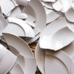 white broken plates on a wooden floor